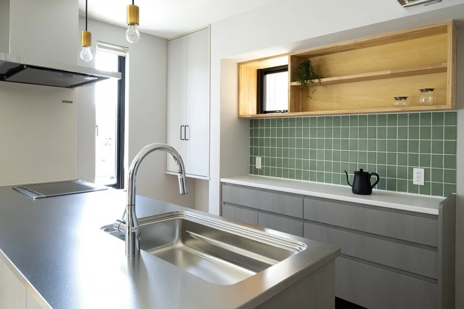 グリーンのタイルがアクセントのキッチン