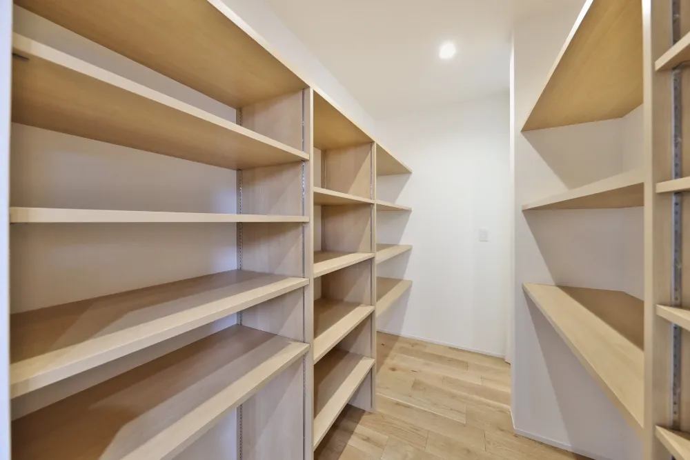 家族用玄関通路を通るとこちらのウォークスルー収納につながります。バッグの他に飲料などのストック品も置ける設計です。