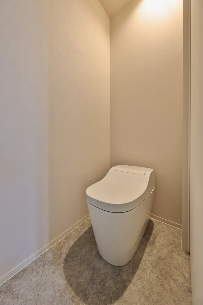 シンプルイズベストなトイレ。グレージュの壁紙を採用。