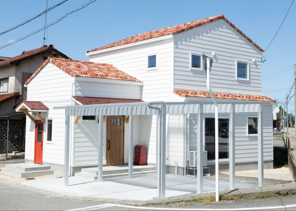 オレンジ色の洋風瓦葺に白いガルバリウム鋼板が目をひく、おしゃれな住まい